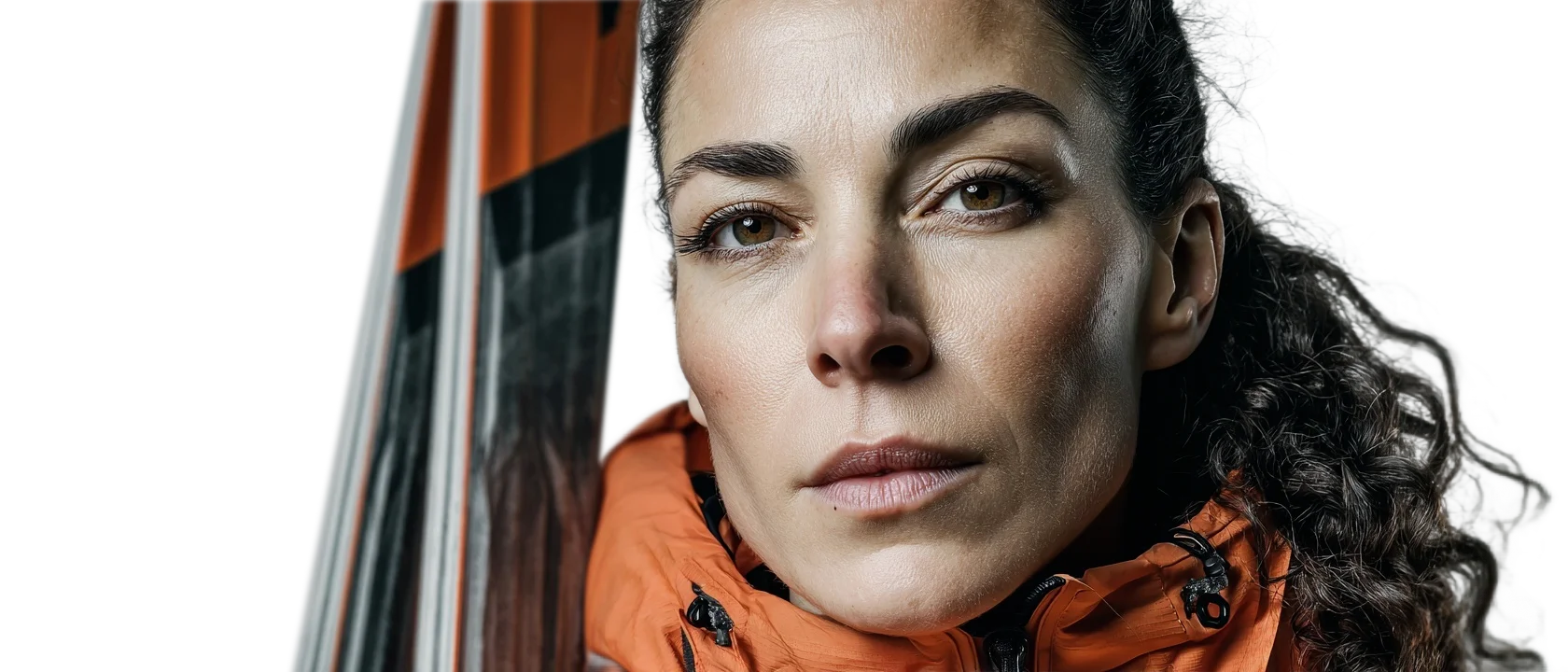 Porträt eines Skifahrers mit orangefarbener Jacke und Skiern, Fokus auf Wintersport und Abenteuer